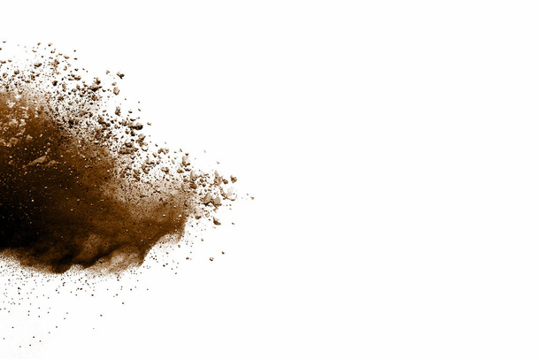 Polvo explosivo marrón sobre fondo blanco. Explosión de suelo seco sobre fondo blanco
 - Foto, Imagen