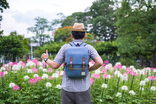 mladý muž turisty batoh jsou stojící palec nahoru za skvělé výkony. na spider květinová zahrada. během cestování o prázdninách. Je to krásná přirozená vegetace - Fotografie, Obrázek