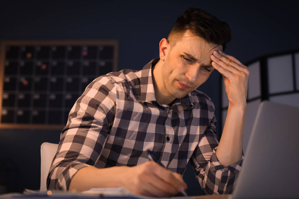 Overworked man with headache in office - Foto, afbeelding