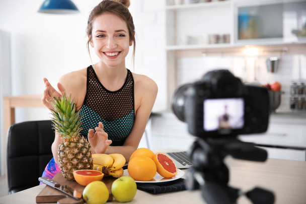 Young blogger with fruits recording video on kitchen - Foto, Bild