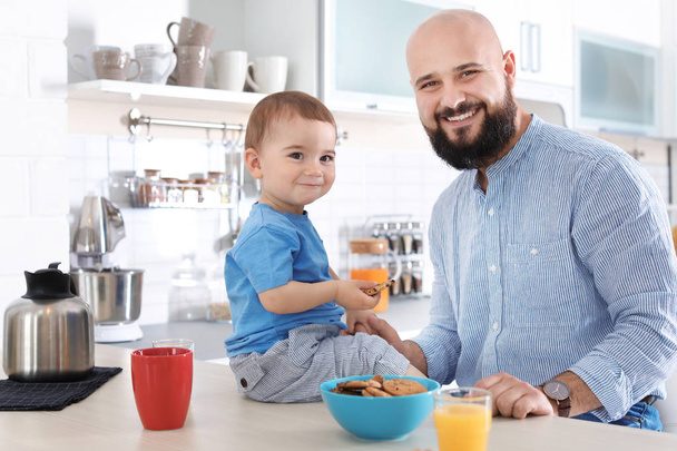 Папа завтракает с маленьким сыном на кухне
 - Фото, изображение