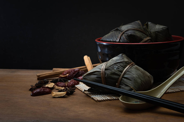 Zongzi lub tradycyjne chińskie pierożki ryżu w liść bambusa na drewniany stół dla Dragon Boat Festival, czyli Festiwal Dumpling - Zdjęcie, obraz