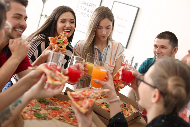 Les jeunes s'amusent avec une délicieuse pizza à l'intérieur
 - Photo, image