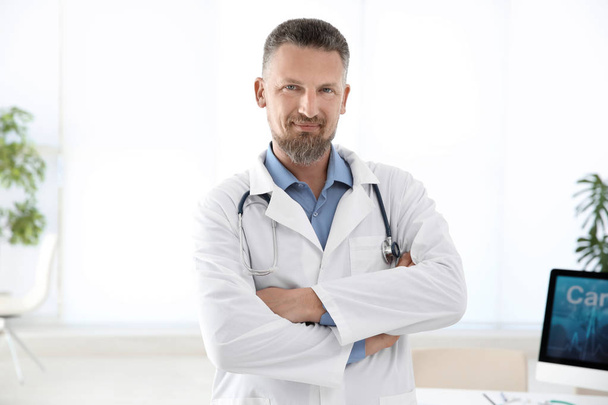 Portrait of male doctor in coat at workplace in clinic. Cardiology center - Photo, Image