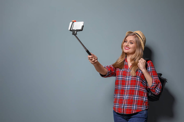 Attractive young woman taking selfie on color background - Fotó, kép