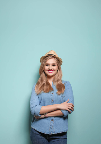 Attractive young woman in stylish outfit on color background - Zdjęcie, obraz