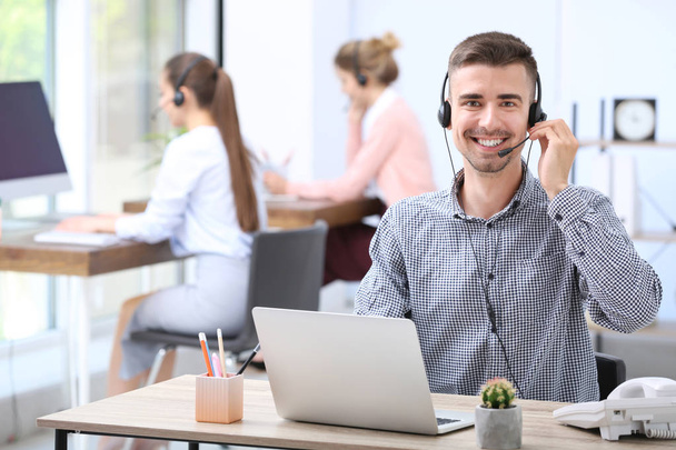 Male receptionist with headset at desk in office - Foto, Imagem