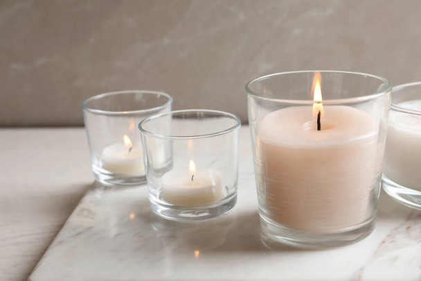 Burning candles in glasses on marble board - Foto, Bild