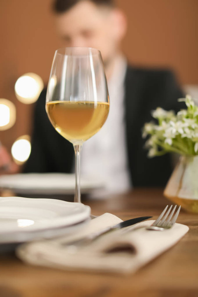 Glass of delicious wine and blurred man on background - Photo, Image