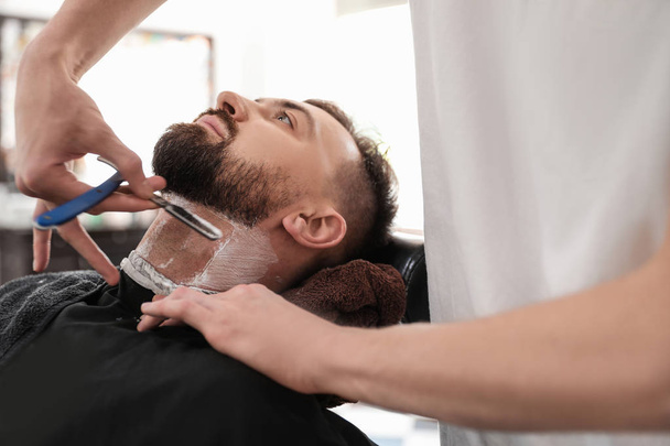 Professional barber working with client in hairdressing salon. Hipster fashion - Foto, Imagen