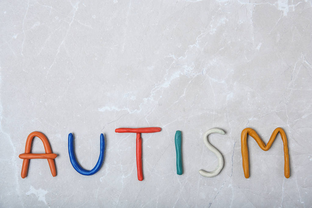 Word AUTISM made of plasticine on light background, top view - Foto, Imagem