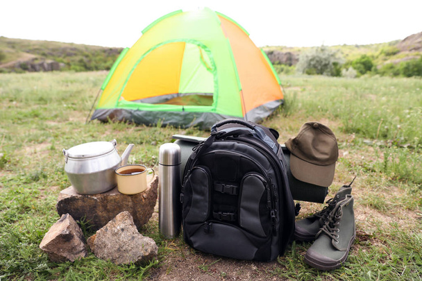 Camping gear and tourist tent in wilderness - Φωτογραφία, εικόνα