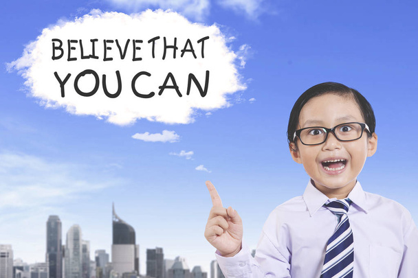 Image of little businessman pointing at a cloud bubble with text of Believe That You Can - 写真・画像