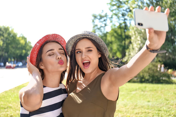 Young women taking selfie outdoors on sunny day - Foto, Imagen