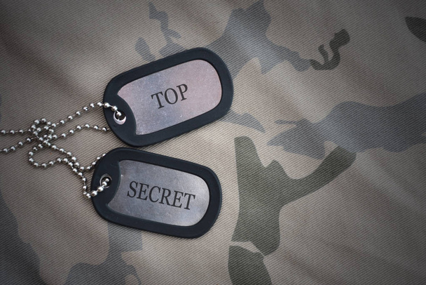 army blank, dog tag with text top secret on the khaki texture background. military concept - Photo, Image