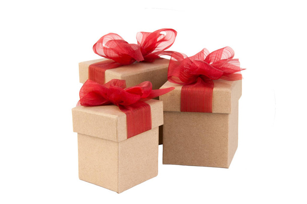 Trois boîtes cadeaux kraft avec des arcs rouges isolés sur fond blanc. Vente de jour de boxe
. - Photo, image