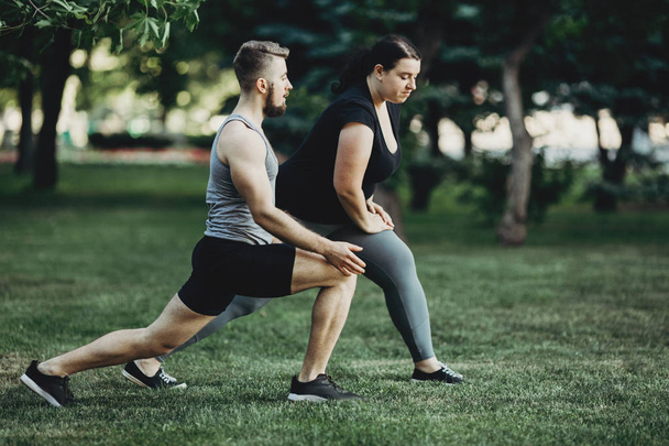 Overweight woman do lunges exercise with trainer - Fotoğraf, Görsel
