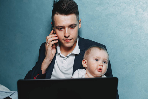 Businessman working at home watching baby daughter - Photo, image