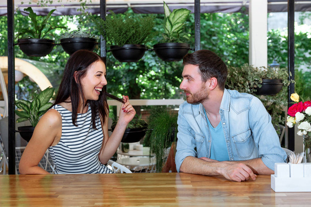 Mladí lidé v kavárně bavit, smát a bavit. Šťastný muž a žena pár relaxační v letní kavárně. - Fotografie, Obrázek