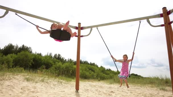 Dos niñas hermosas en swing Mar Báltico en Jurmala, Letonia
. - Imágenes, Vídeo