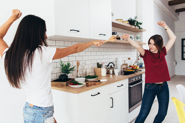 Dos mujeres preparan juego de comida en la cocina
 - Foto, imagen