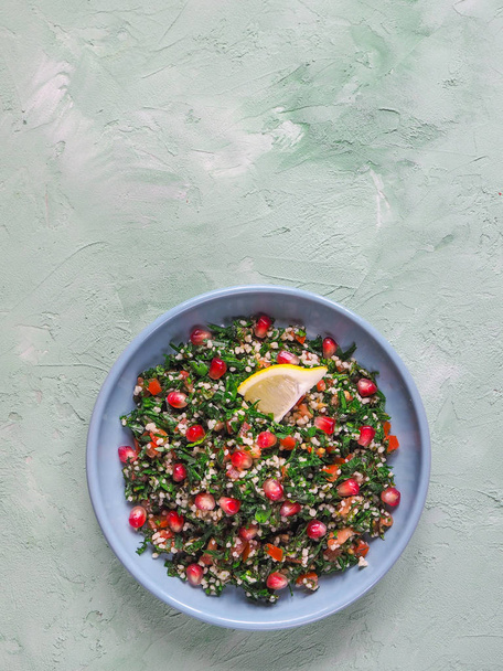 Yeşil Beton masada bir kasede kuskus salatası Tabbouleh. - Fotoğraf, Görsel