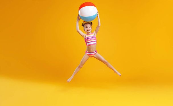  funny happy child   jumping in swimsuit and swimming glasses on colored backgroun - Photo, Image