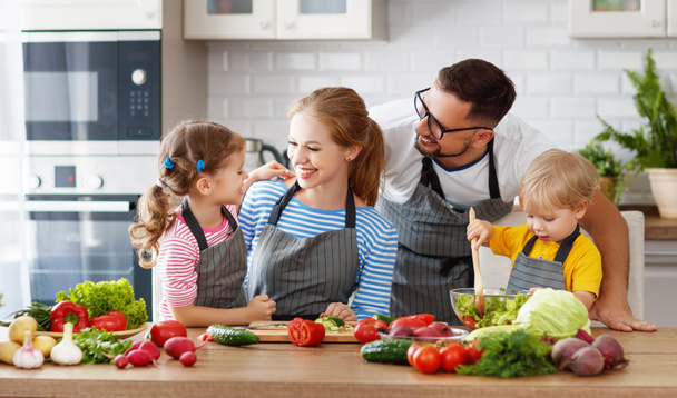 famiglia felice con bambini che preparano l'insalata vegetale a hom
 - Foto, immagini