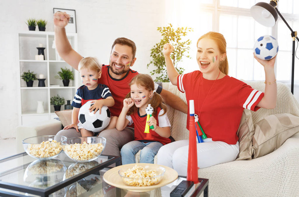 Uma família de fãs assistindo a um jogo de futebol na TV no hom
 - Foto, Imagem