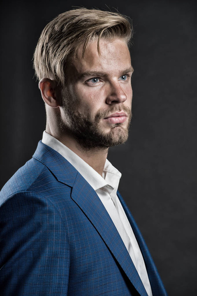 Man bearded strict face with hairstyle, dark background. Masculinity concept. Businessman attractive cares about appearance. Man bearded unshaven guy looks handsome well groomed in formal wear - Fotografie, Obrázek