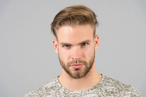 Man bearded confident face, grey background. Skin care concept. Man bearded unshaven guy looks handsome and well groomed. Guy attractive cares about his appearance. Macho with smooth healthy skin - Photo, image