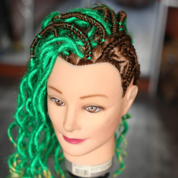hair thin braids and green dreadlocks on a mannequin head - Photo, Image