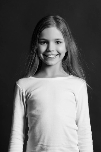 Girl with smile on cute face on dark background - Zdjęcie, obraz