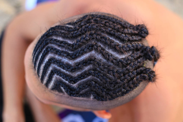El hombre con el corte de pelo de las trenzas africanas con la foto de la foto
 - Foto, Imagen