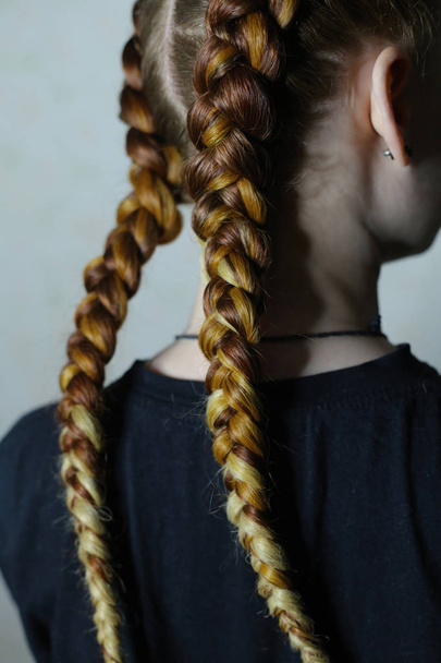 kapsel van twee vlecht met kanekalon op het haar van een rood meisje, - Foto, afbeelding