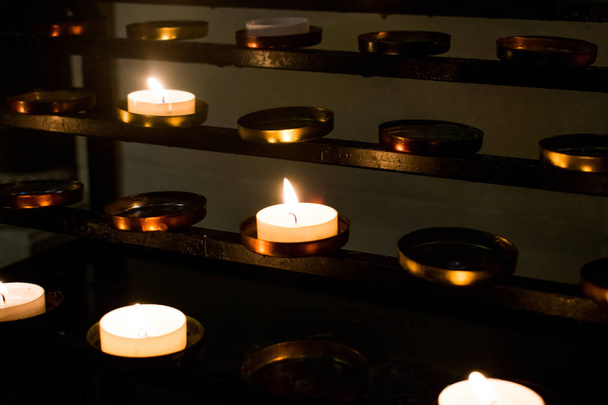 Een groep van kaarsen verlicht in een katholieke kerk als rememberence - Foto, afbeelding