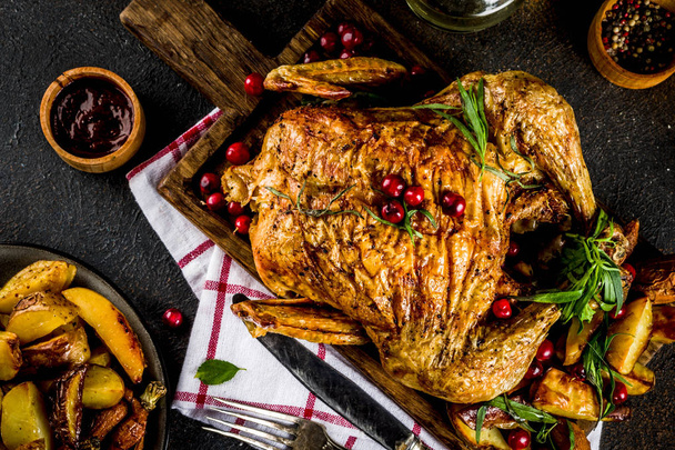 Vánoce, den díkůvzdání potraviny, zapečené pečené kuře s brusinkovým a byliny, podávaný s restovanou zeleninou a omáčky na tmavě rezavý stůl, kopie prostoru nad - Fotografie, Obrázek