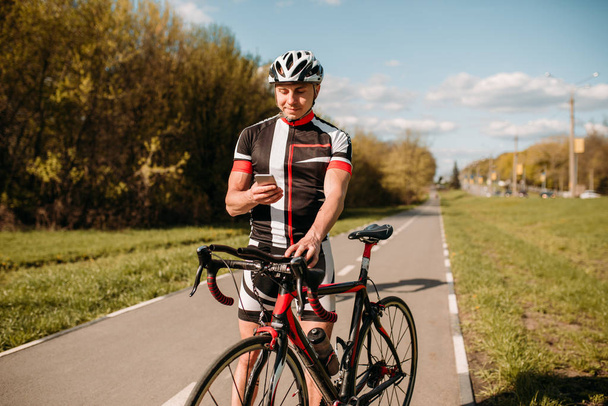 Велосипедист в шлеме и спортивной одежде, тренировка на велосипеде. Мужской спортсмен едет на велосипеде. Тренировка на велосипедной дорожке
 - Фото, изображение
