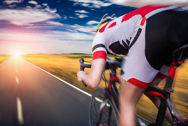 male cyclist in helmet and sportswear riding bicycle, back view  - Φωτογραφία, εικόνα