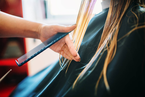Женщина-косметолог ведет расческу, женщина в парикмахерской. Парикмахерская в студии красоты
 - Фото, изображение
