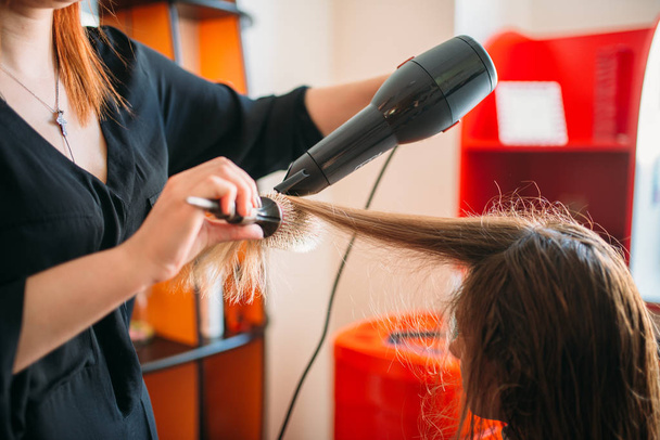 Stylist Droogrek met een haardroger, vrouwelijke haarsnit in kapsalon. Kapsel maken in de schoonheidssalon - Foto, afbeelding