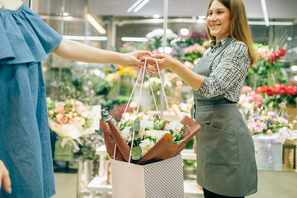 Flower shop business concept, florist in apron and female customer in floral boutique.  - Foto, Imagen