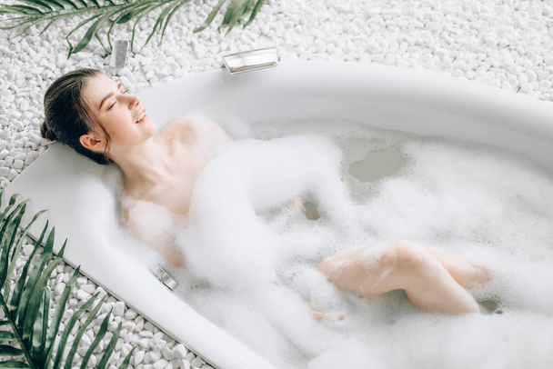 attraente donna sdraiata in bagno con schiuma, relax, salute e concetto di cura della pelle
 - Foto, immagini