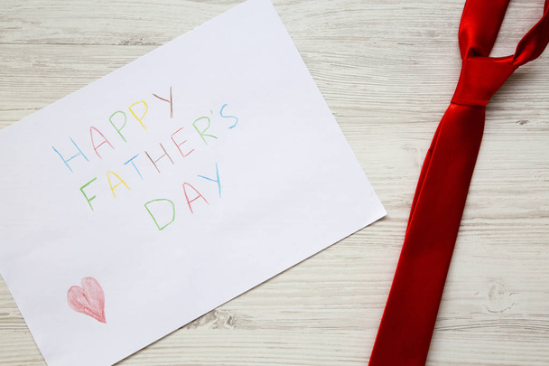 Happy Father's Day inscription with red tie on white wooden background. - Fotografie, Obrázek