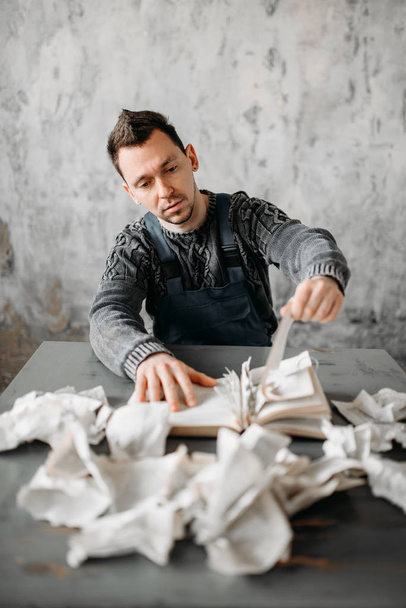 Mann reißt Seiten aus Buch, verlassenes Haus - Foto, Bild