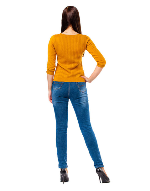 Happy brunette woman in blue jeans and mustard sweater, isolated on white background - Photo, Image