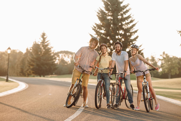 Група молодих людей з велосипедами на дорозі
. - Фото, зображення