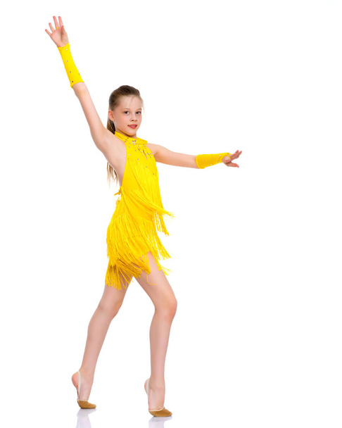 A cheerful little girl is dancing. - Фото, зображення