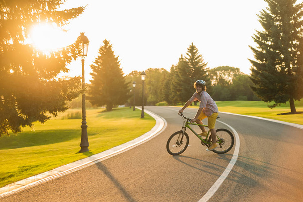 Молодий радісний чоловік на велосипеді на відкритому повітрі
. - Фото, зображення