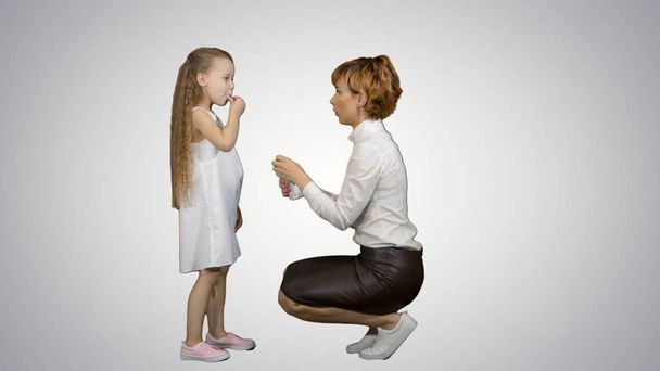 Worried mother giving medicine to her daughter on white background - Photo, Image